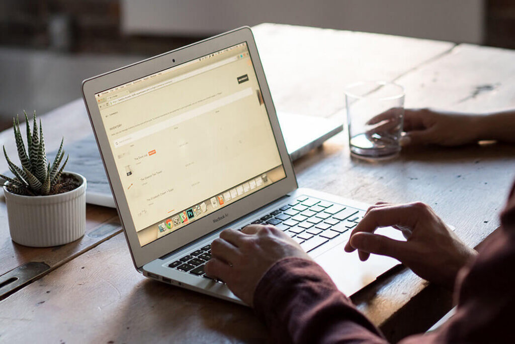 Image showing a laptop on a table with a woman's hands above the keyboard