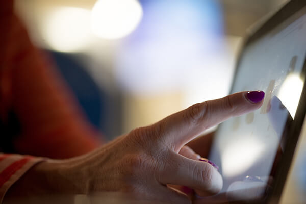 Image of someone tapping on a tablet device